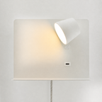 This white articulating wall light combines focused bedside illumination with an integrated shelf and charging port. 