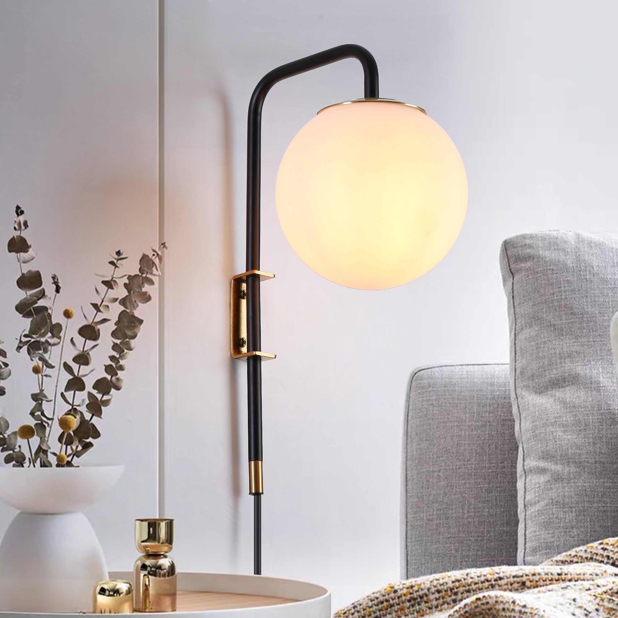 Opal globe plug-in wall sconce with matte black arm and brass accents