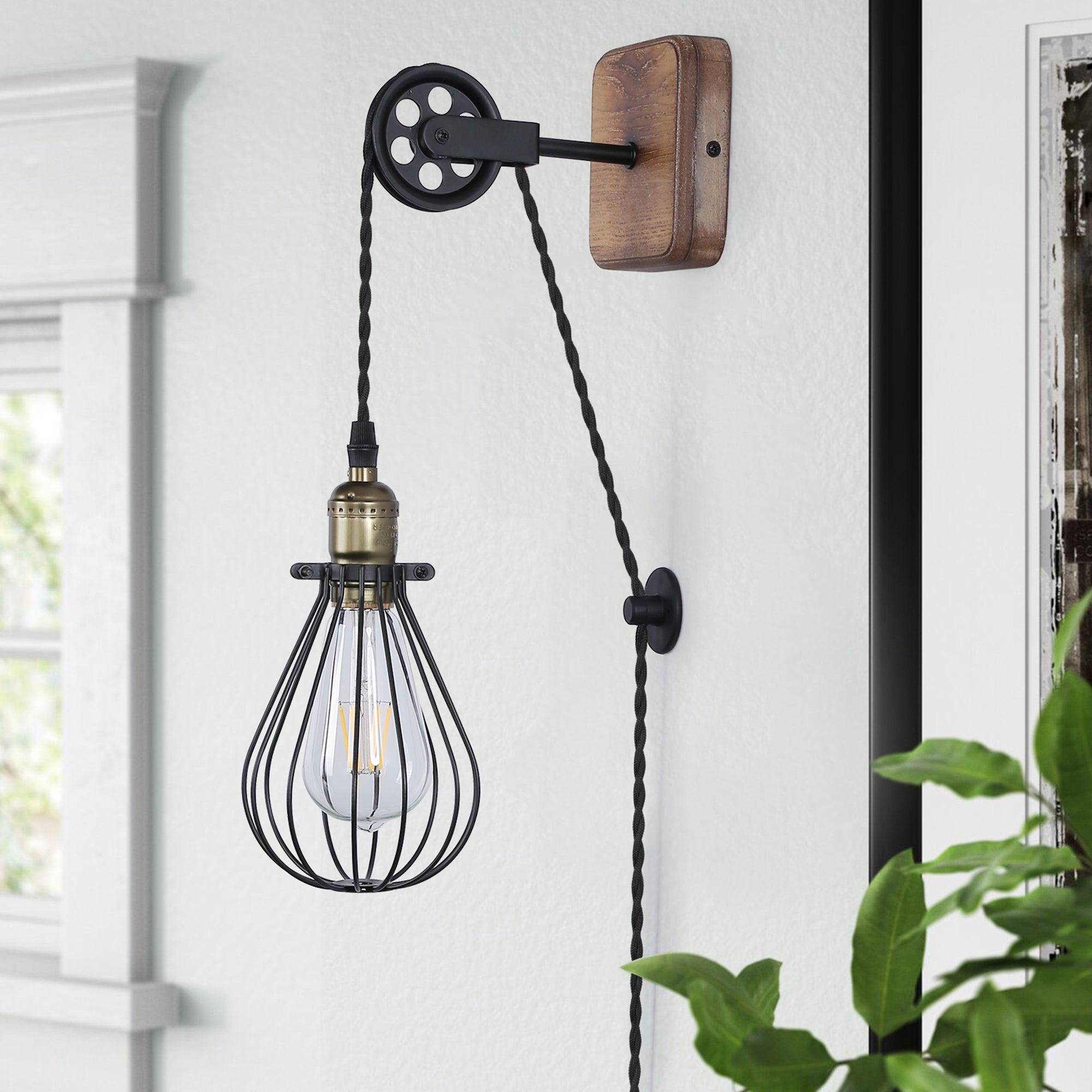 Industrial pulley plug-in wall sconce with natural wood backplate and black wire cage shade
